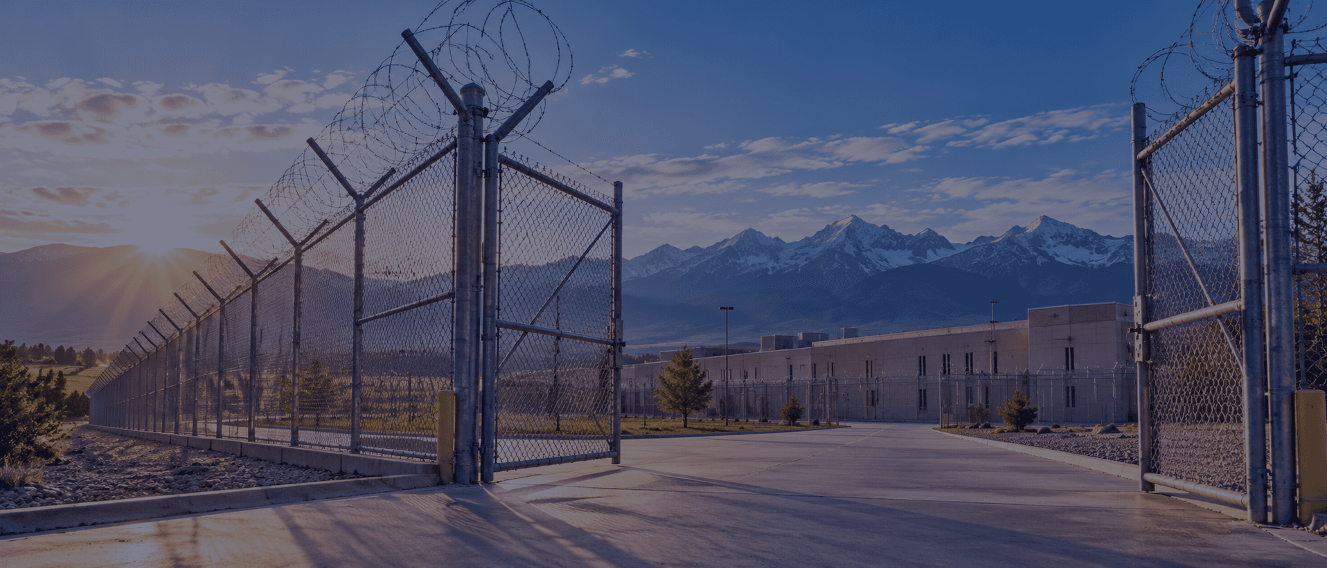 Secure detention facility entrance with a gated perimeter and razor wire in Colorado